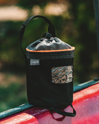 Thumbnail for Orange-trim CYNCH bag on the hood of a red truck