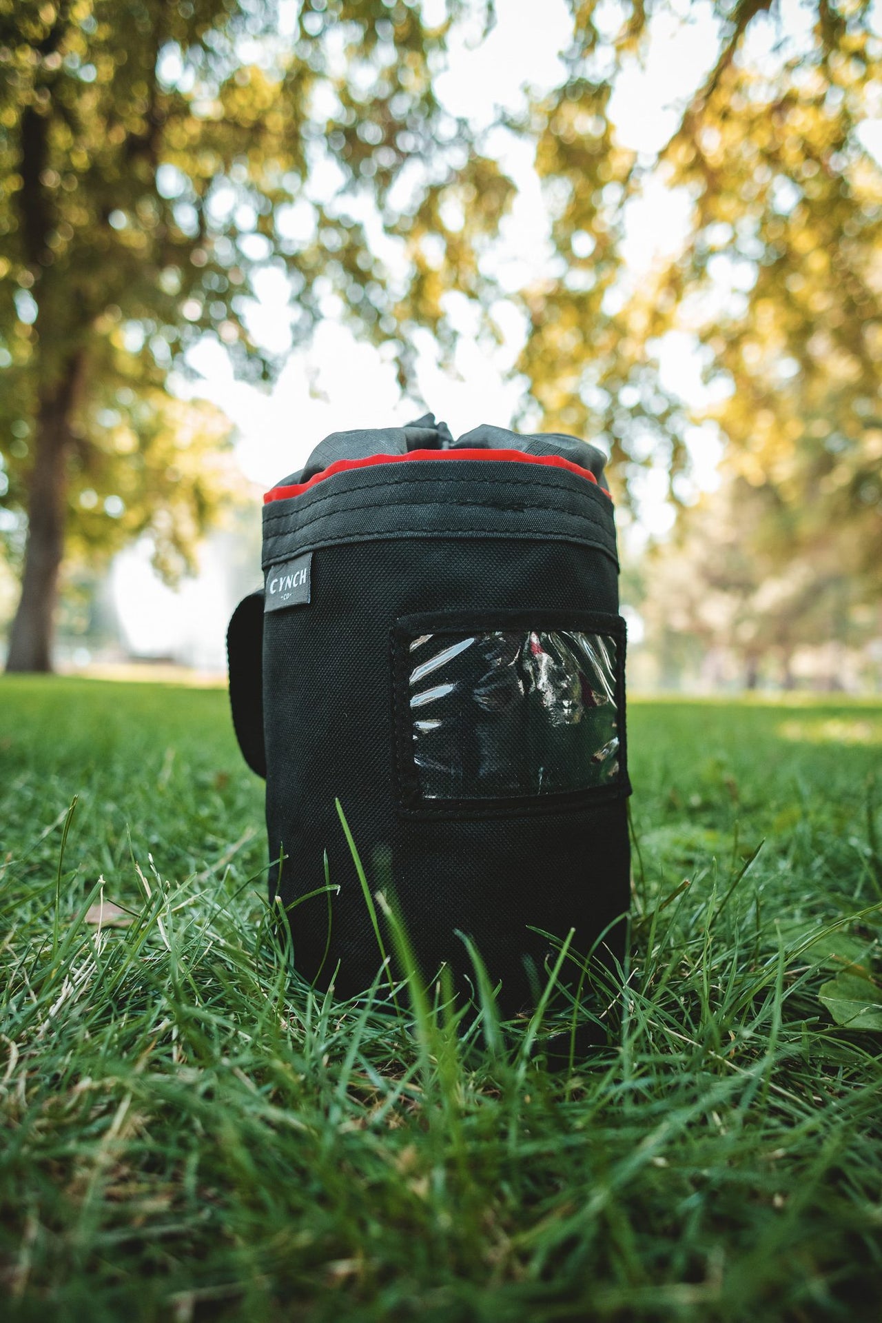Red-trim CYNCH bag in a park