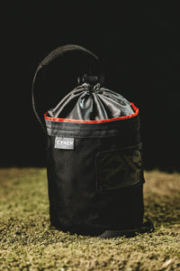 Thumbnail for Red-trim CYNCH bag on turf against a dark background