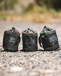 Thumbnail for Three CYNCH bags in different trim colors standing on gravel