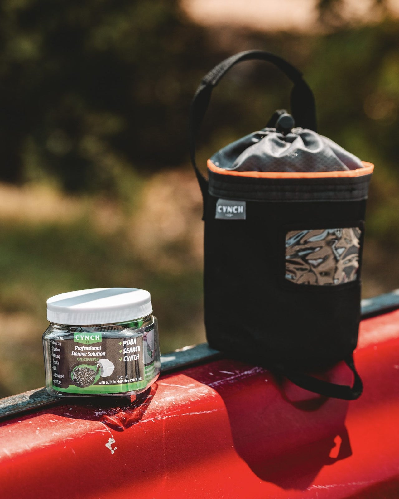 16 oz CYNCH jar beside a CYNCH bag on a red truck